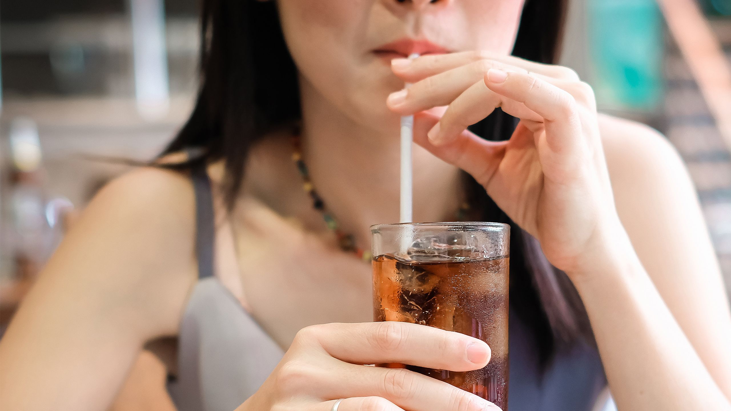 A woman drinks soda from a glass