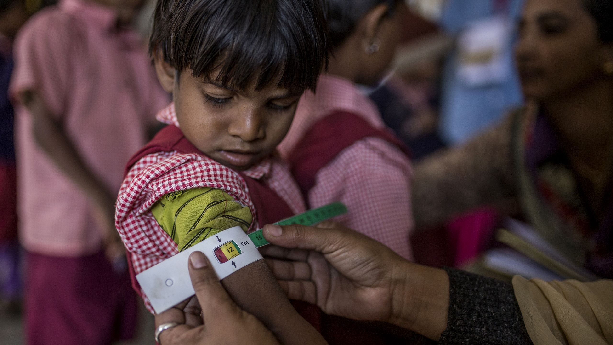 在印度，一名儿童在接受上臂测量